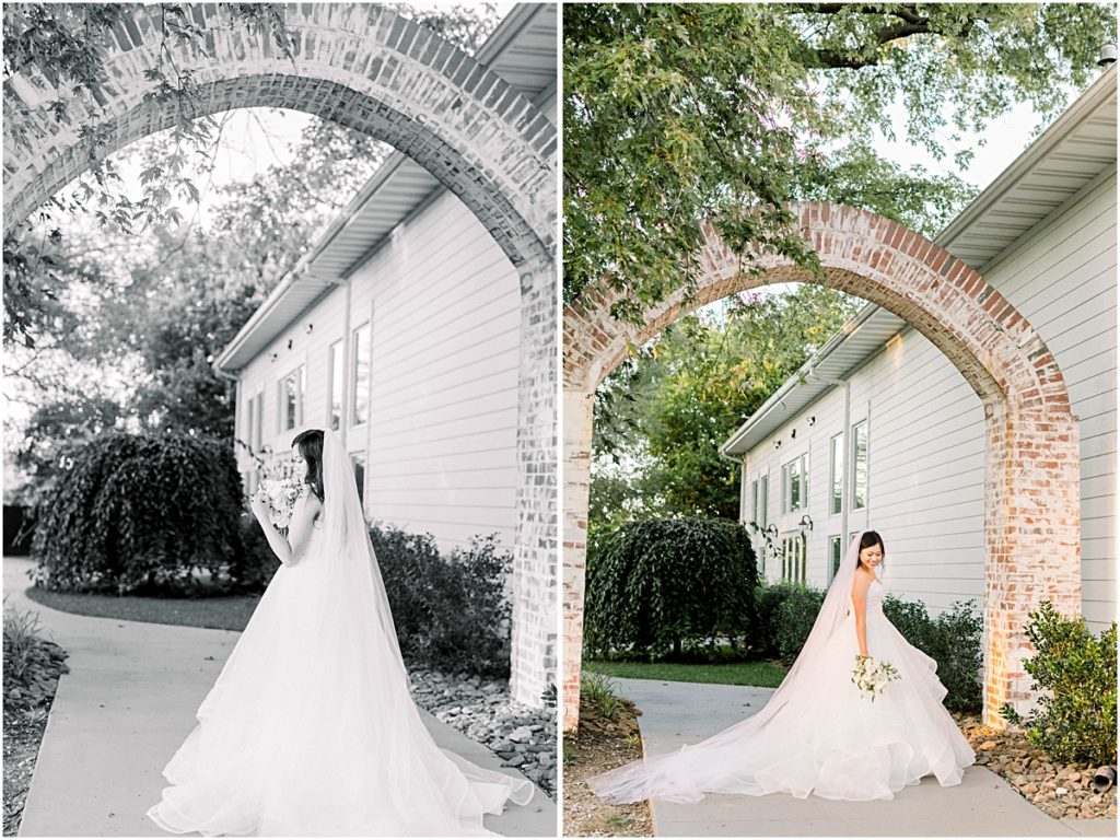 Carina standing aside old brick arch at Arkansas Wedding Venue
