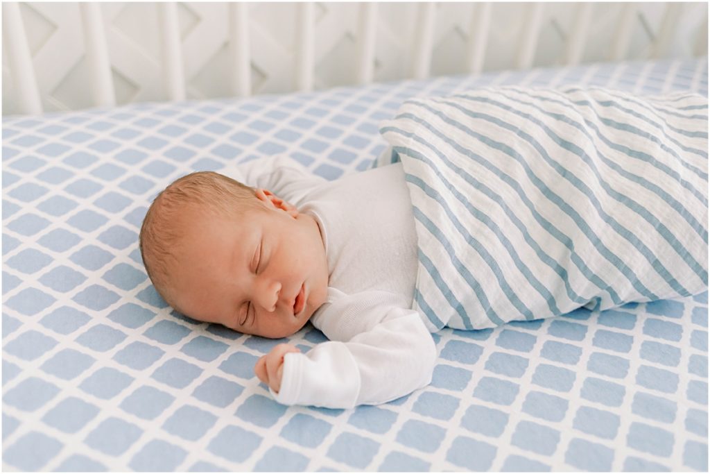 Baby James in crib, tucked under a striped blanket 
