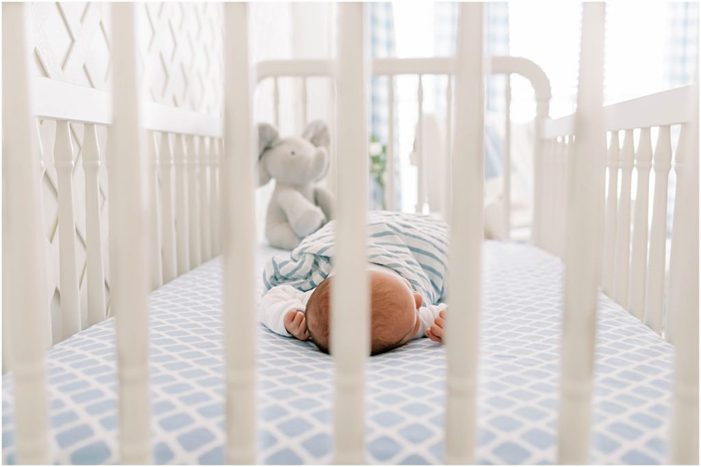 Picture of Baby James in crib, through crib bars in foreground during Newborn Photography session
