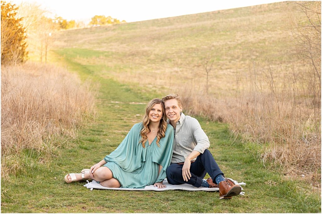 Jillian and Craig sitting in a field during Bella Vista Engagement