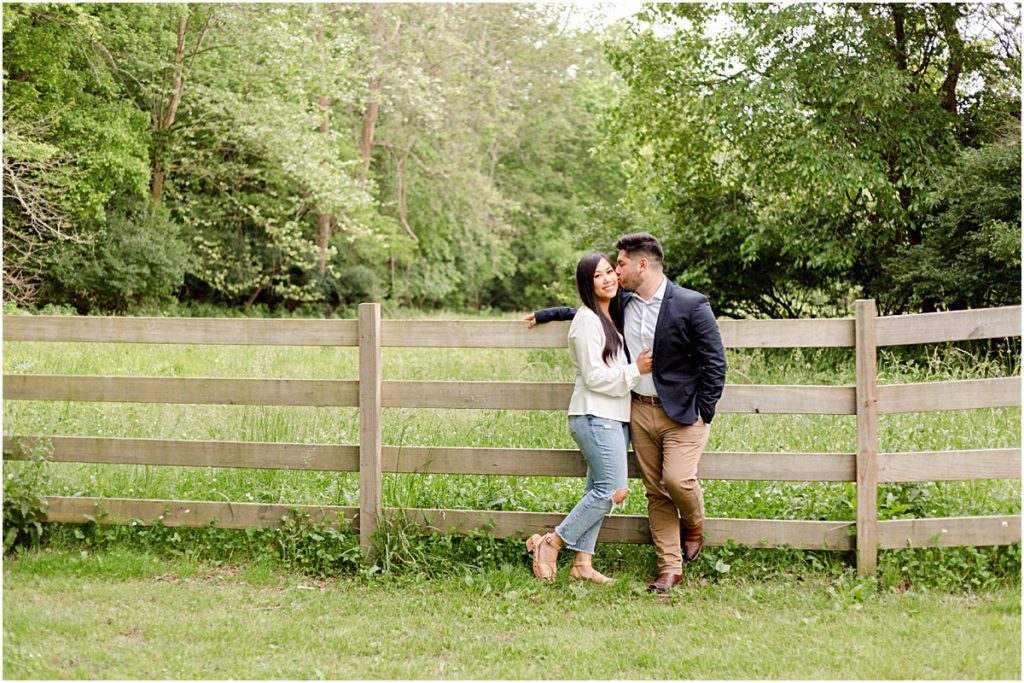 Jorge and Carina in front of a field, hugging during Fayetteville Engagement Session
