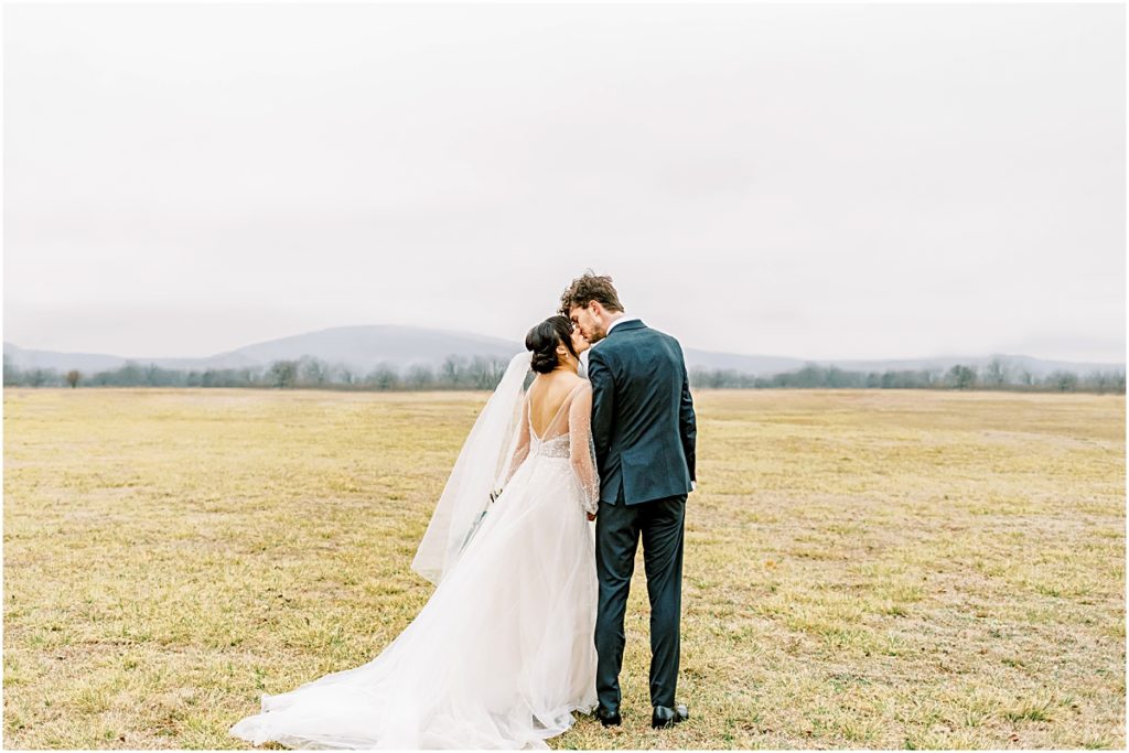 Lawrence and Emily kissing in a field during their Arkansas Elopement 