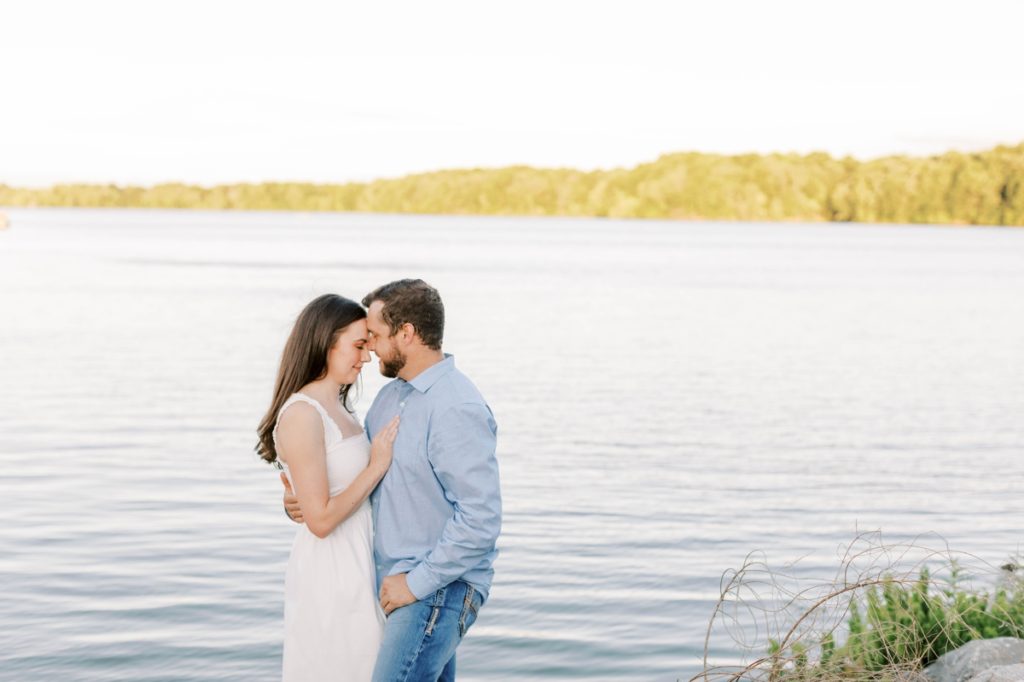 A man and woman press their foreheads together and take in the moment during their engagement session at Lake Fayetteville.