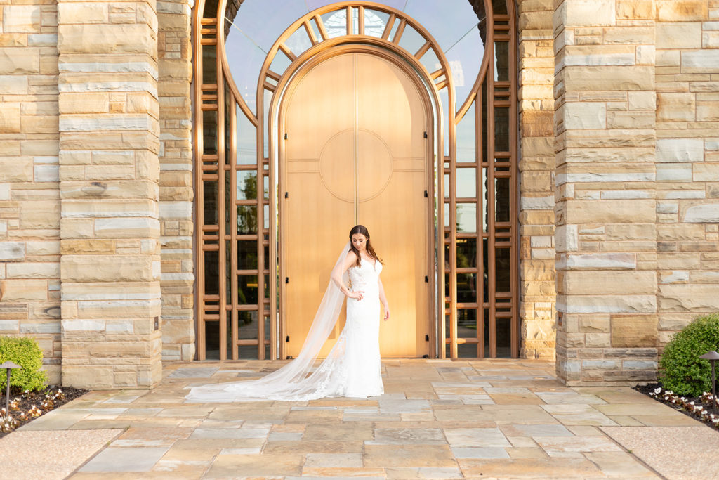 Bride standing in front of a large door in front of her wedding venue 