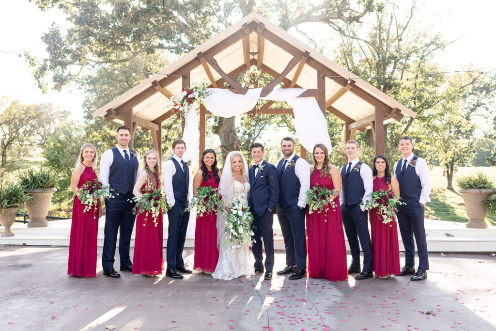 Bride and Groom with bridal party standing in front of the arbor 