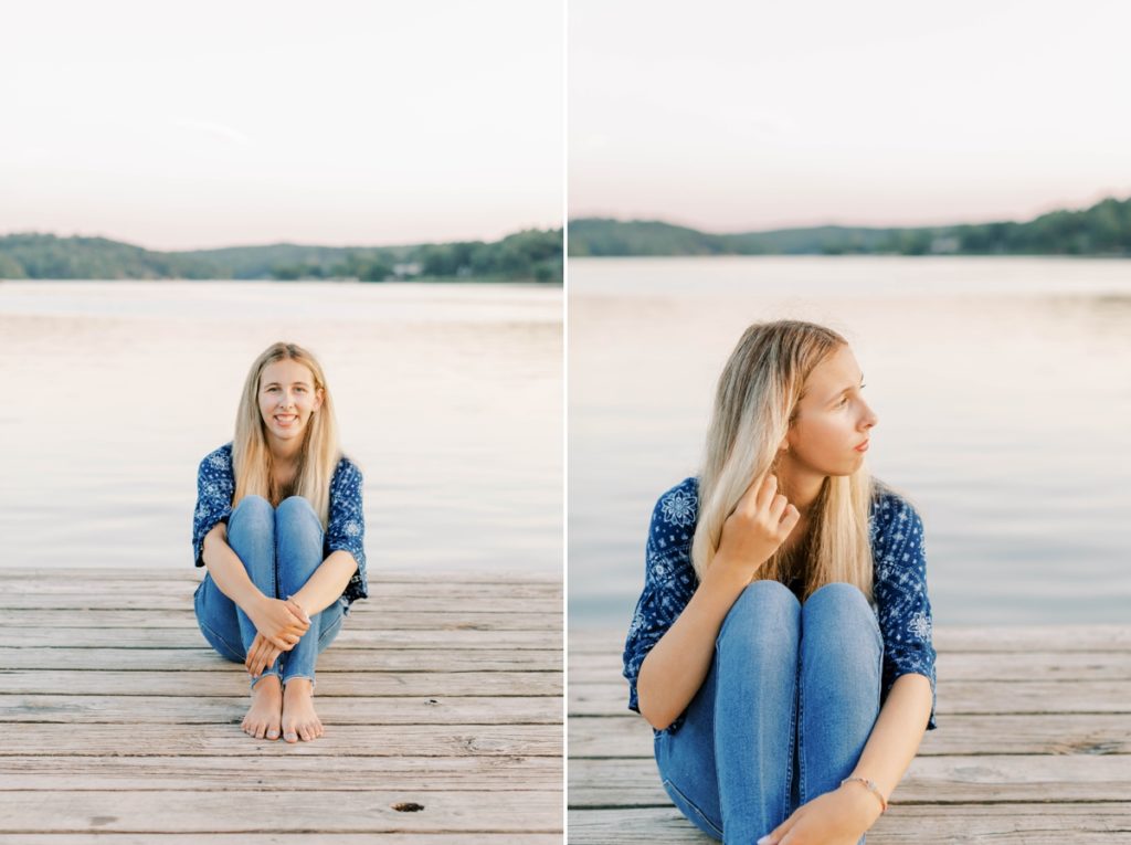 Natalie sitting on a dock and playing with her hair during her senior session.