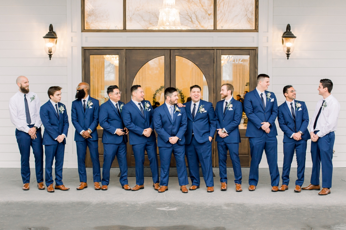 The groom and his groomsman in their navy suits on his wedding day.