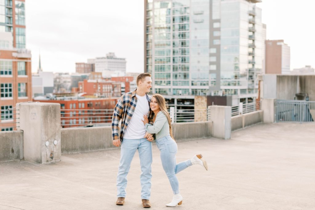 Casual engagement session outfit, jeans and tshirts on a garage rooftop.